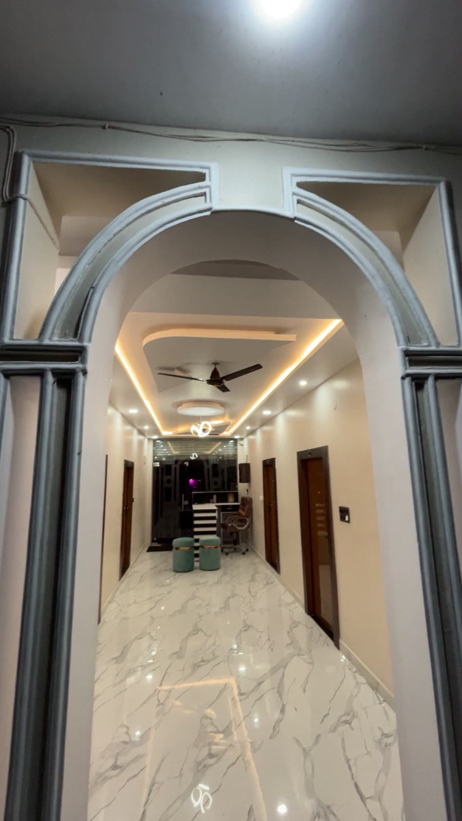 Marble-floored corridor with cove-lit ceiling