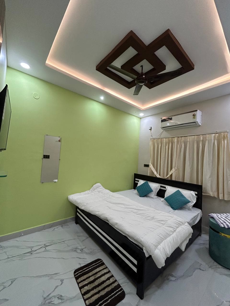 Deluxe AC room with white duvet and teal cushions