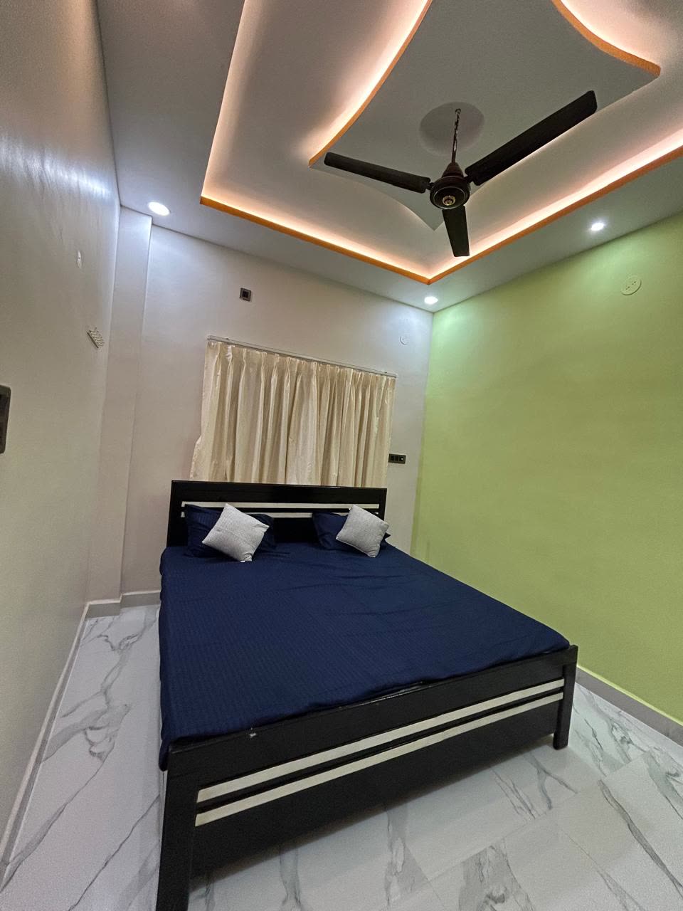 Classic room with navy bed and curved, lit ceiling